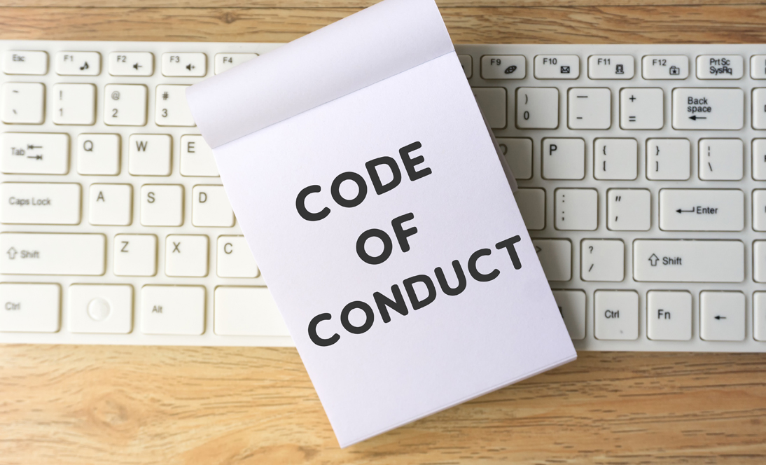 Image: wood background with code of conduct in white paper on top of it